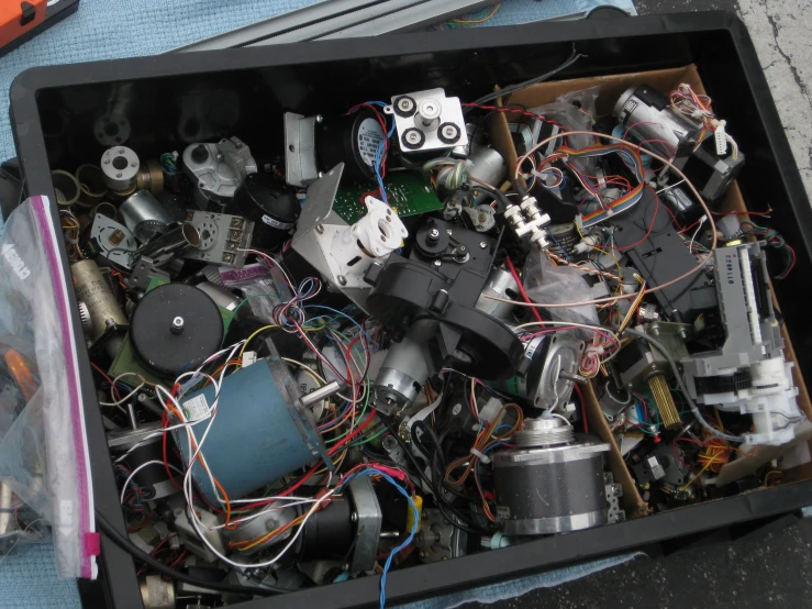 a box full of assorted metal objects such as electrical devices