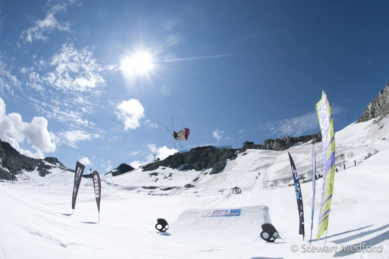 several skiers are in the air above a snowy hill