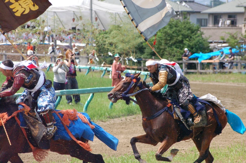 people dressed as indians riding horses and holding flags