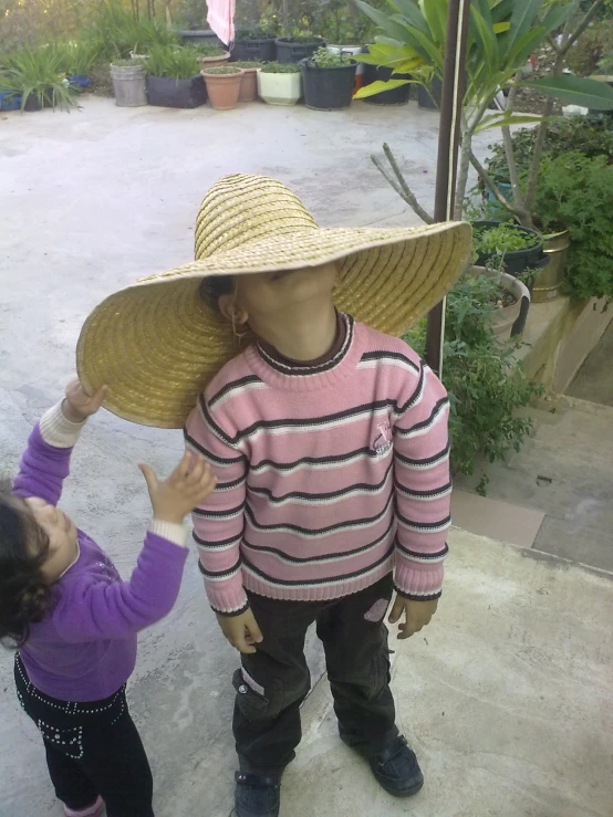 a boy and girl are playing together wearing hats