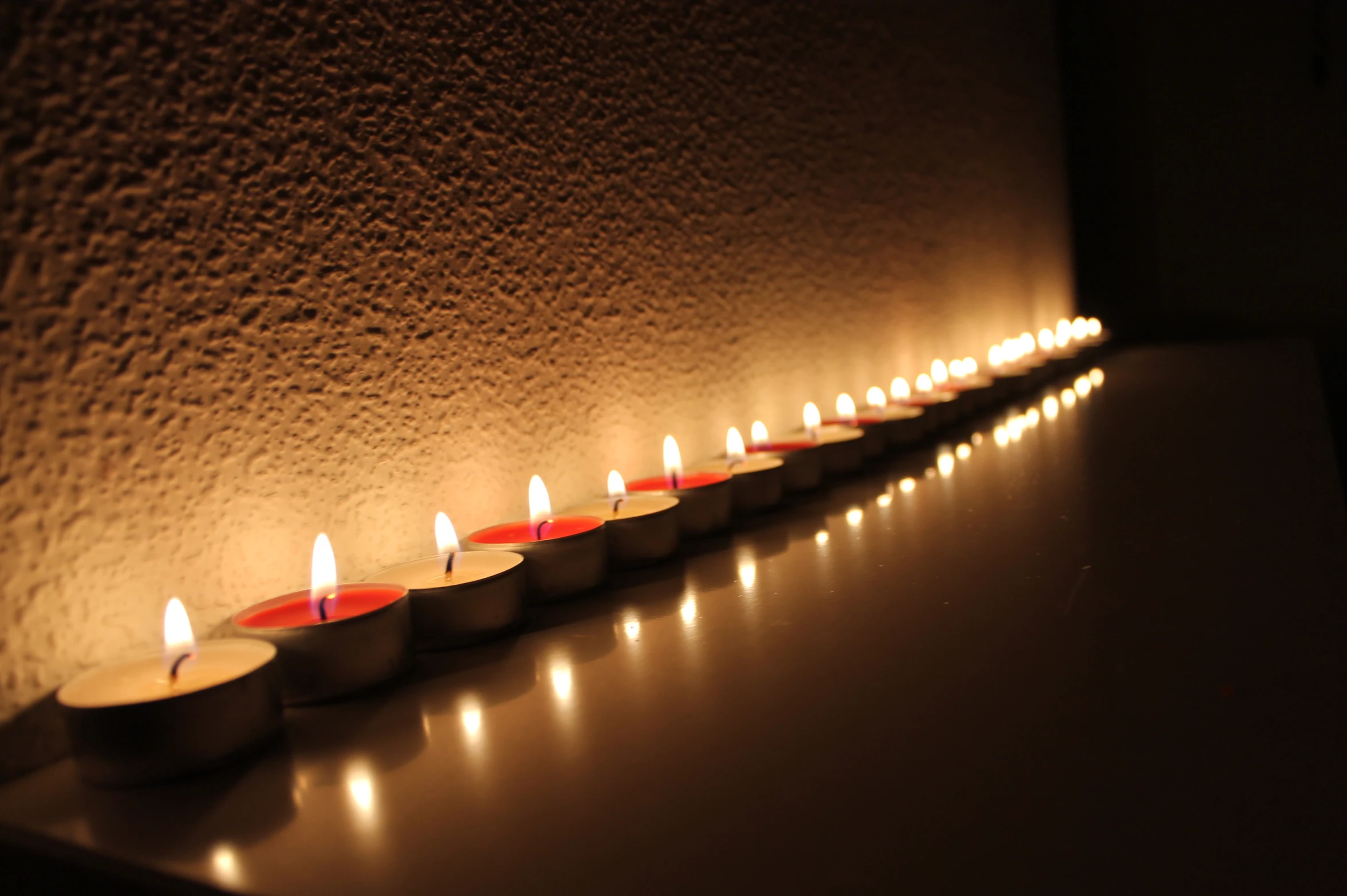 seven candles arranged on top of a counter lit