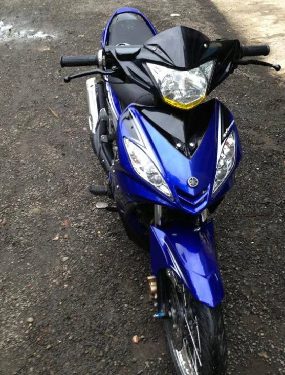 a blue motorcycle parked on the side of a road