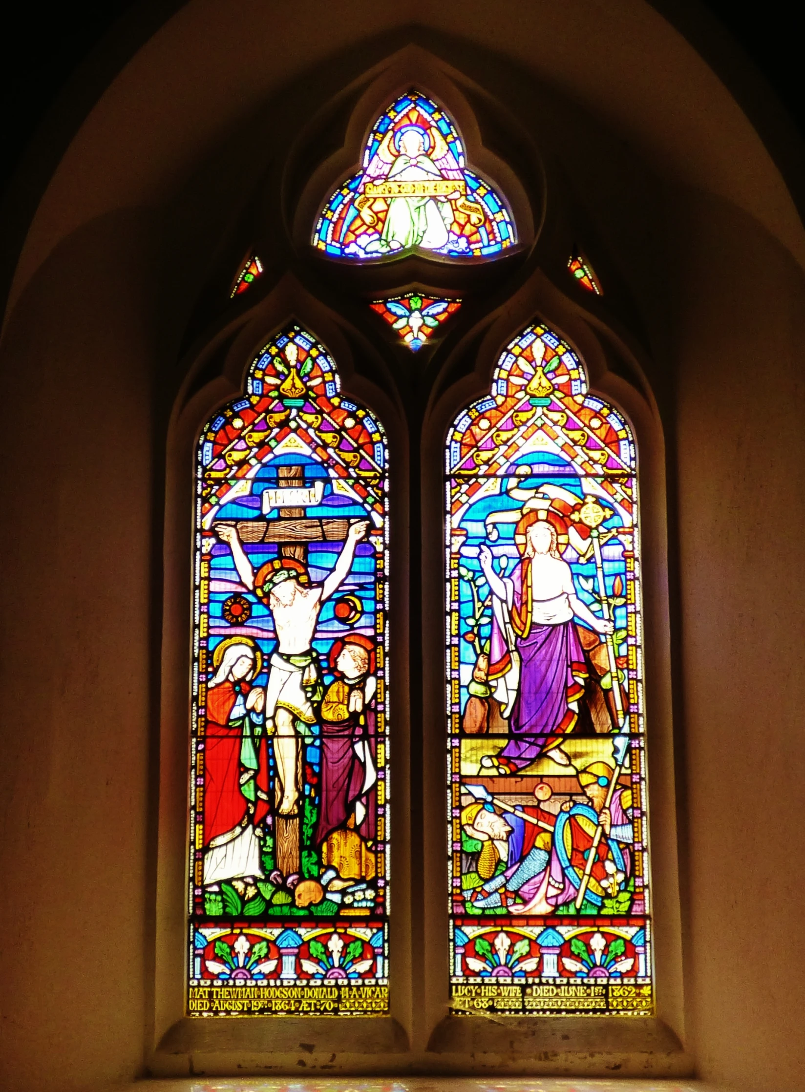 two stained glass windows are on display in a church