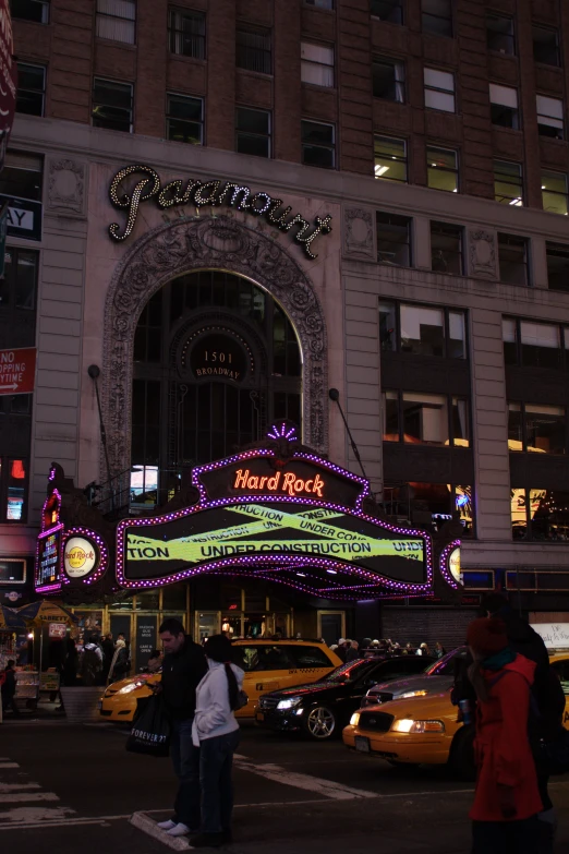 a group of people walk across the intersection in front of a building