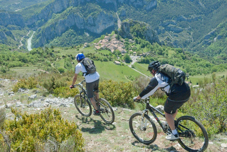 two men riding bikes on a steep hill