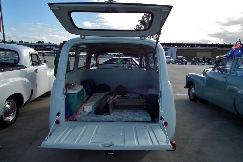 the back of a small blue car with luggage in it