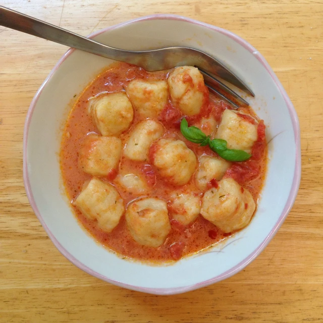 food with sauce, meatballs and a silver fork in a bowl