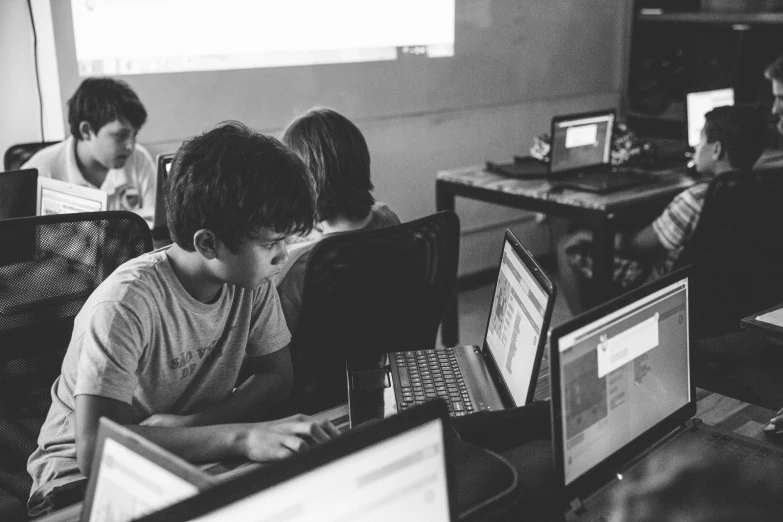 a black and white image of s in a classroom working on their computers