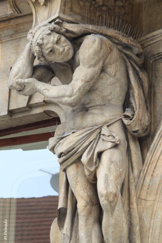 a statue sits in front of a building with a window and a building across the street