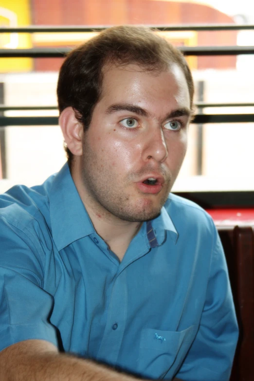 a man in a blue shirt looking at the camera