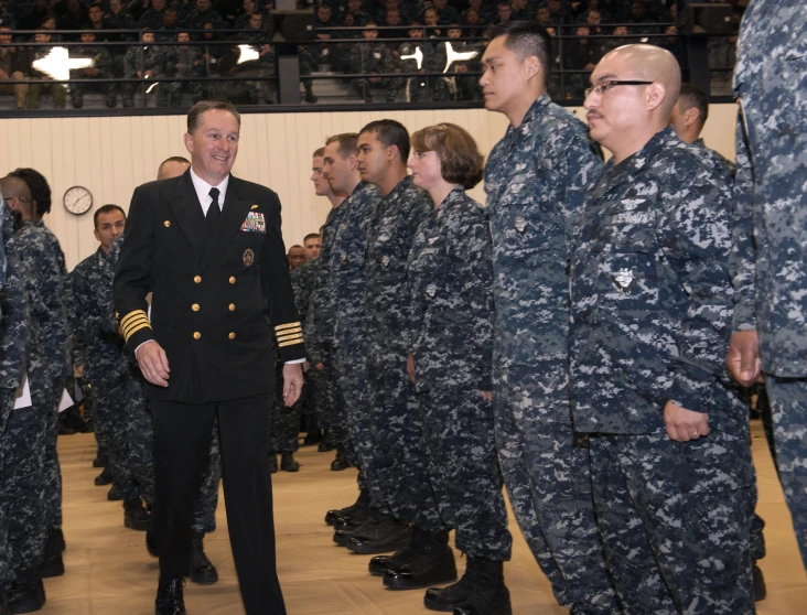 a man in military attire standing with other people