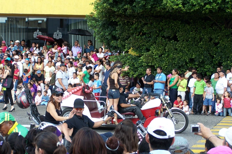 several men ride motorcycles while many crowd of people are watching