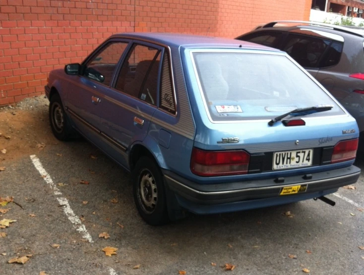 there is a blue car parked in a parking lot