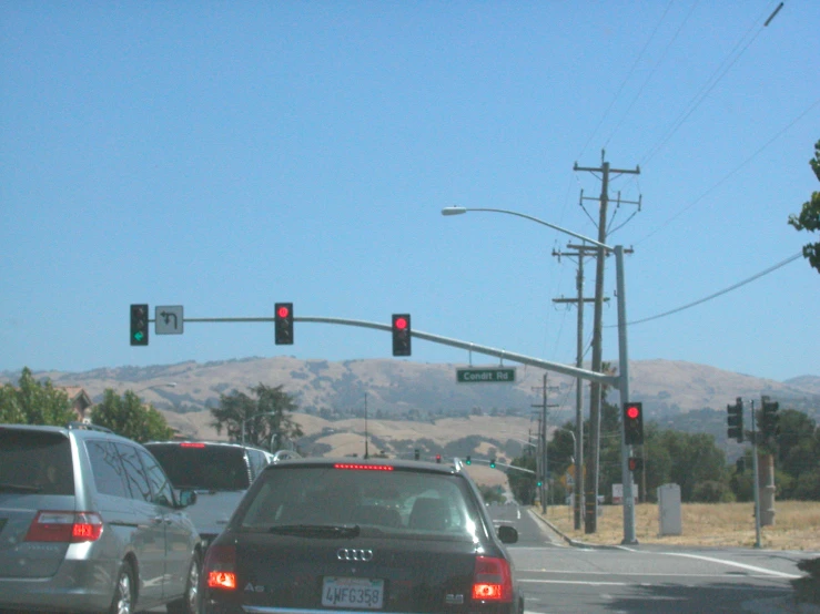 a street sign is visible above cars waiting at a light