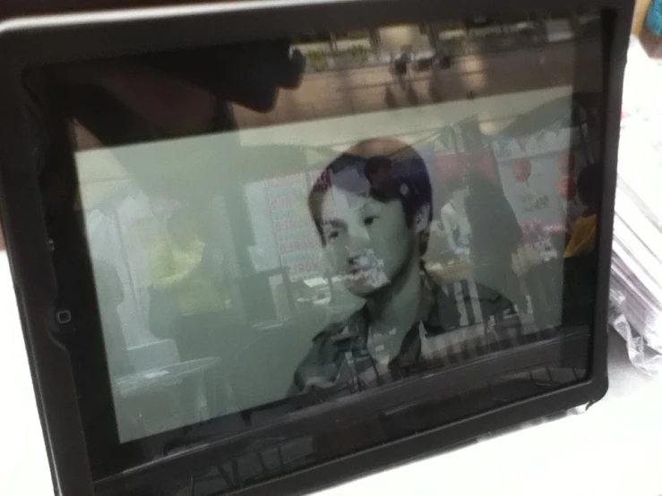 an old television with a picture of a boy behind it