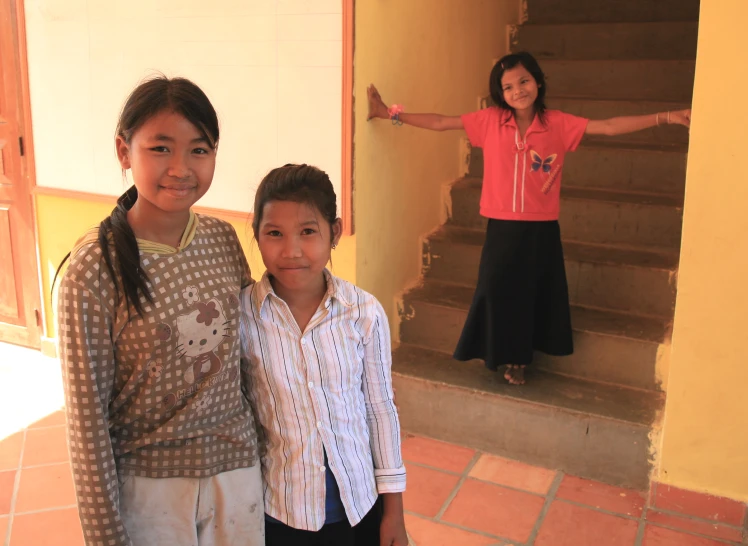 a woman stands next to her children outside the door