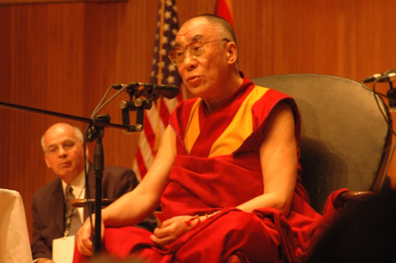 a person sitting down in a chair with microphones