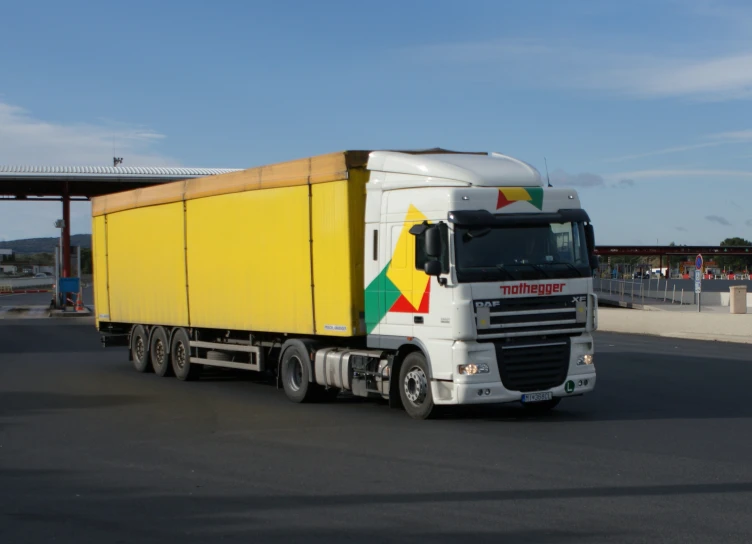 a white and yellow truck driving down the road