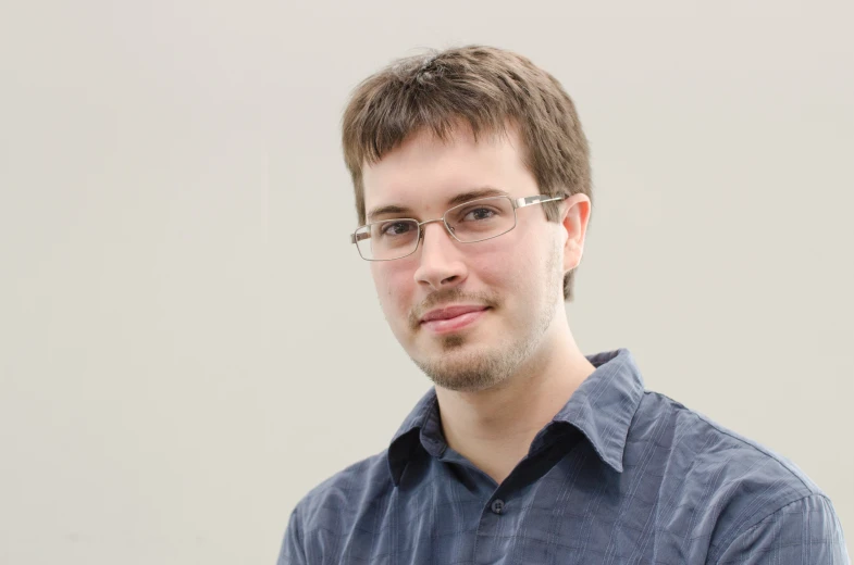 a man with glasses looking at the camera