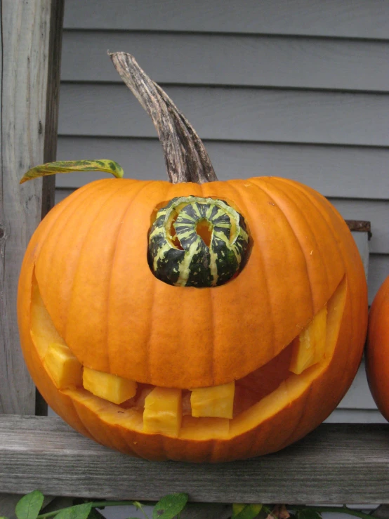 two carved pumpkins on a bench with one in the center