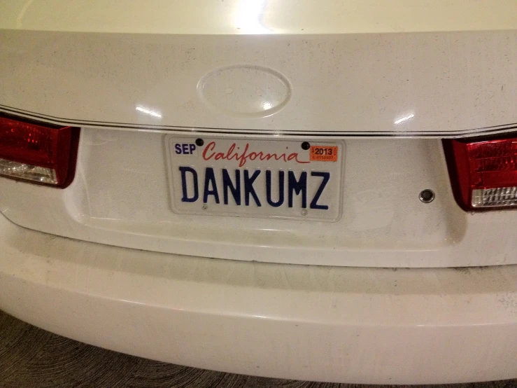 a white car has a license plate with dankuum