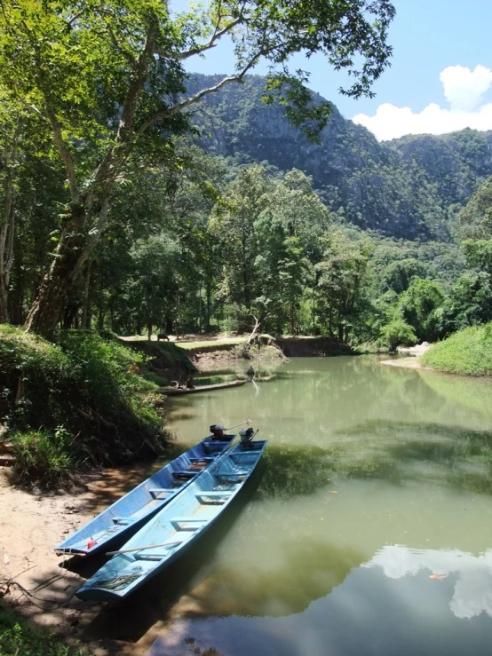 a couple of boats tied up next to each other on a river