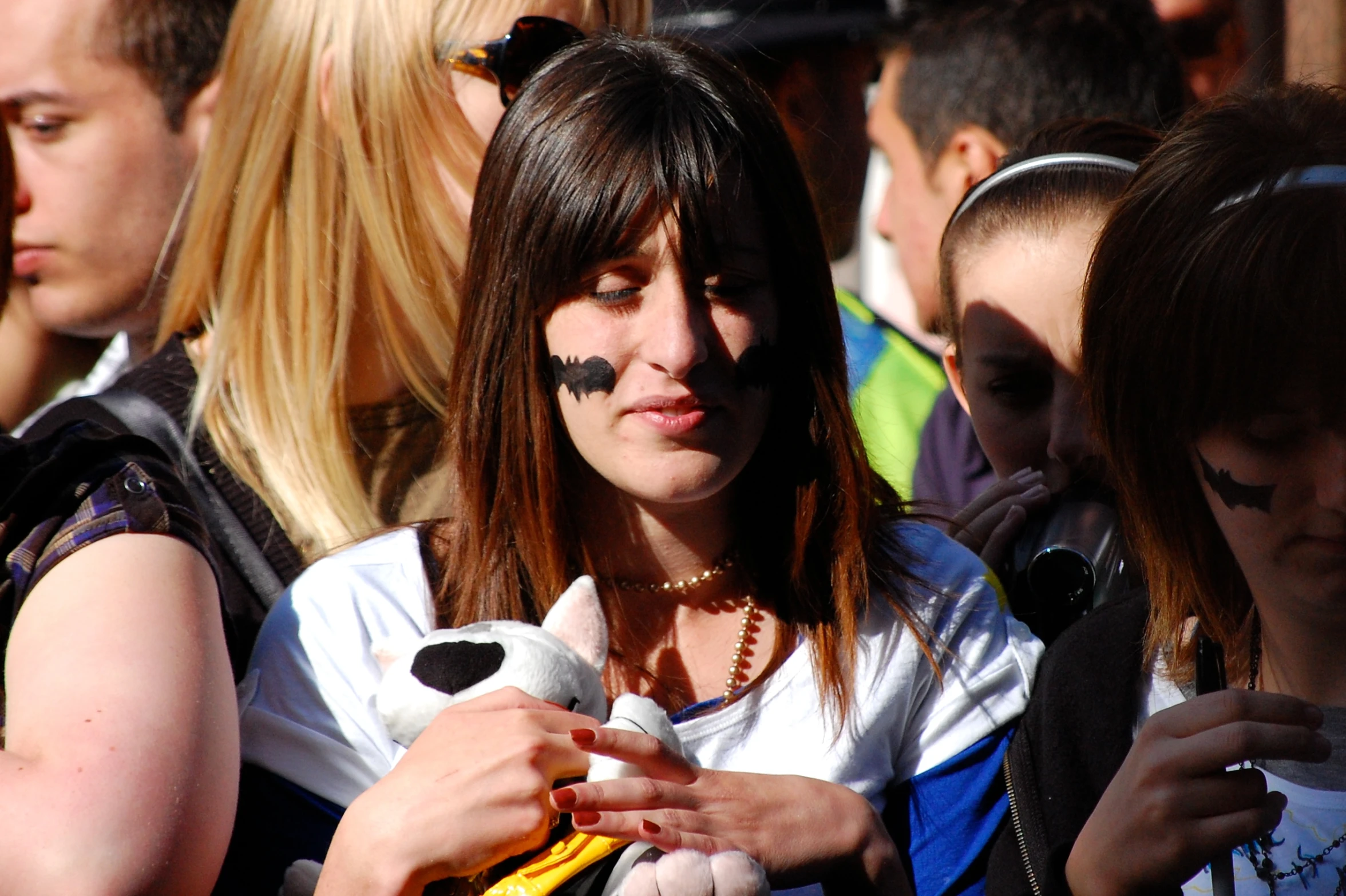 a  with black eyebrows and makeup is looking at her cell phone