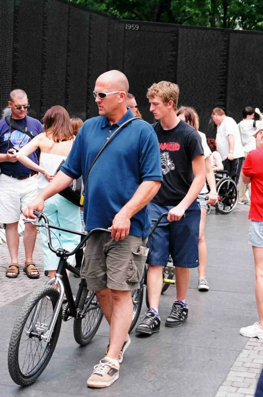 a man riding a bike down a street with people watching