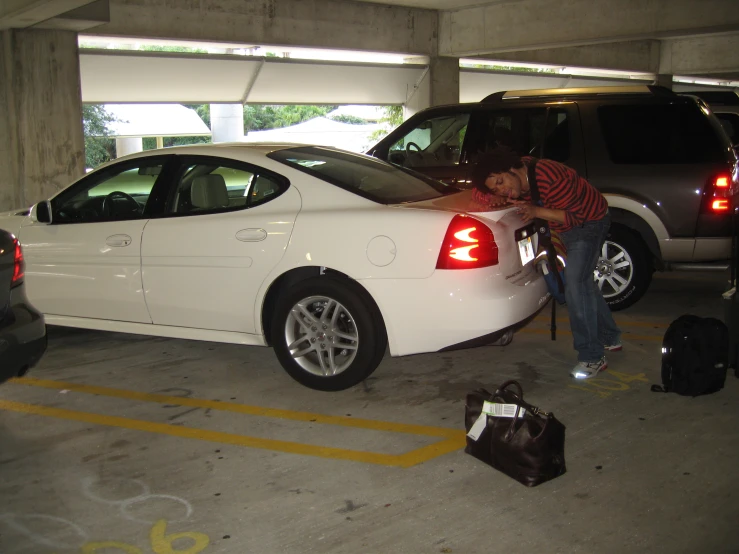 a man putting a bag in a car trunk