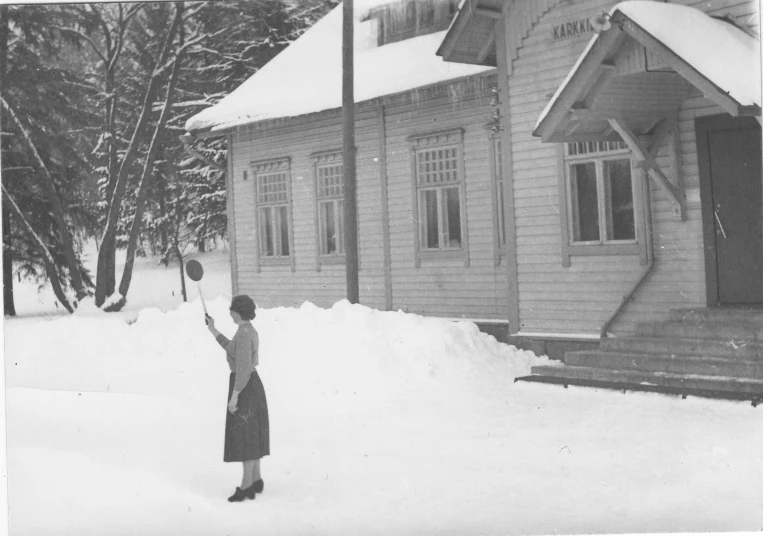 a woman standing in the snow with a tennis racket
