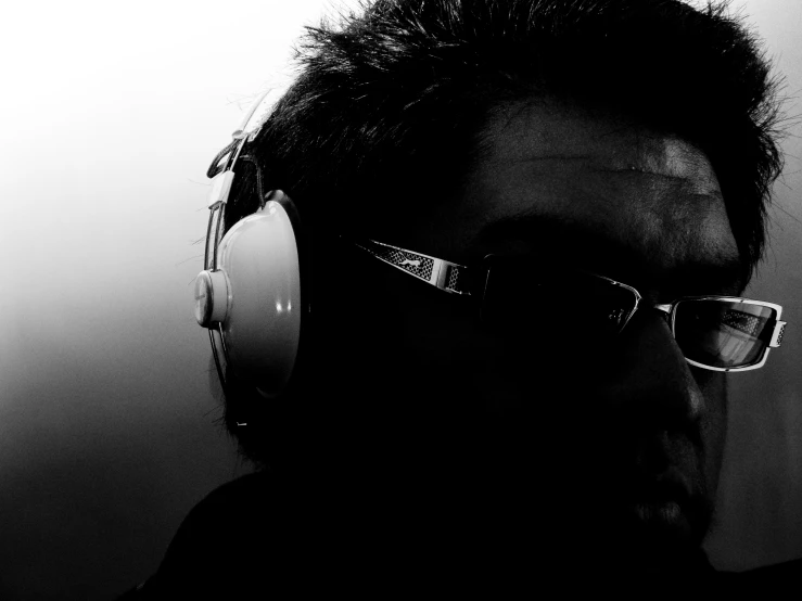 a person wearing headphones and glasses in a dark room