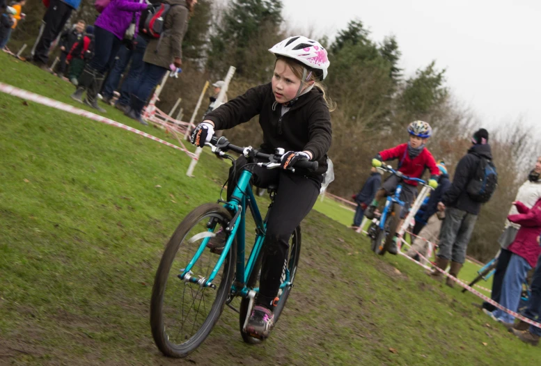  riding her bicycle along the side of a muddy trail