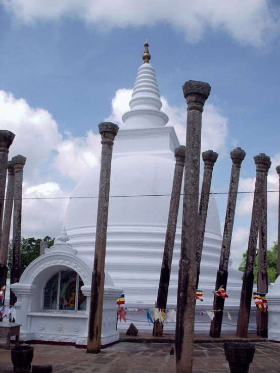 many large poles are in front of a large white building