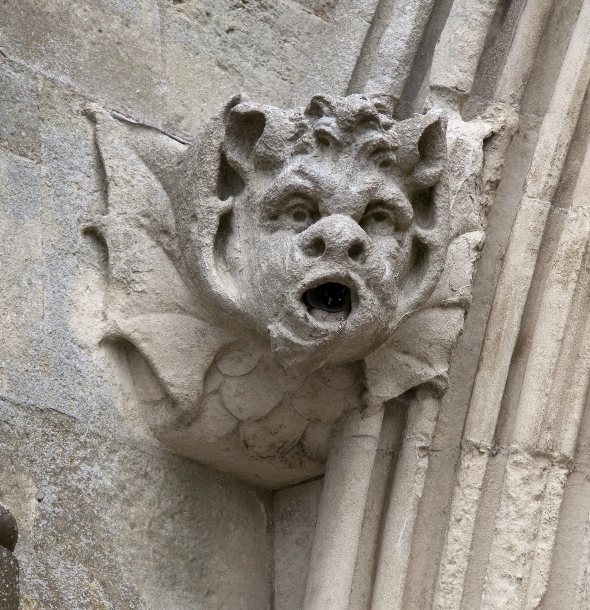 a carving on the side of a building with a bear face