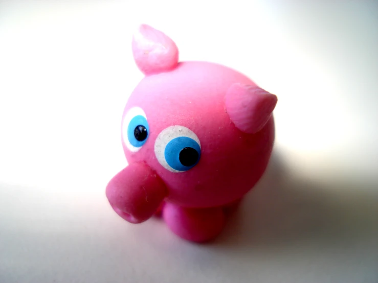 pink animal with blue eyes is on the table