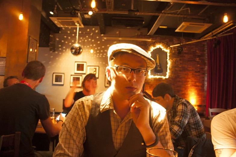 a man in a cap sits at a table with drinks