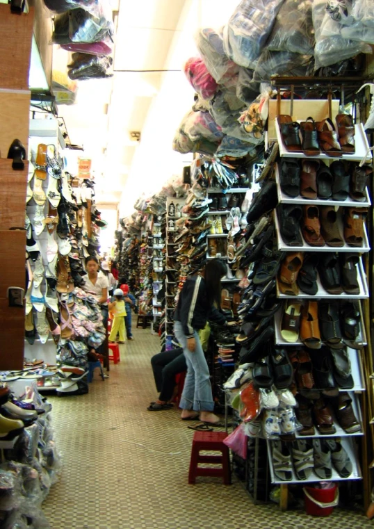 people in a large room are shopping for shoes