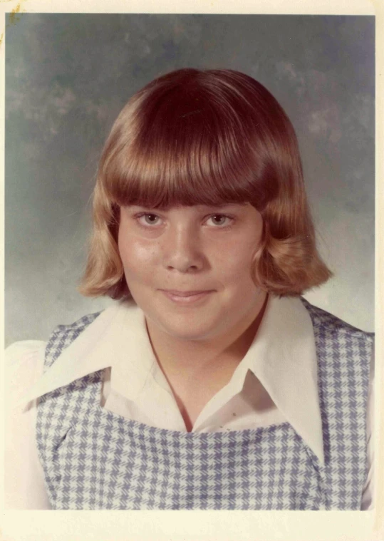 a po of a young woman in a blue and white checkered dress