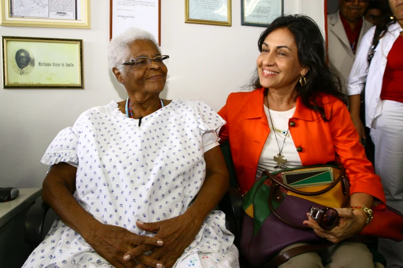 an older woman with glasses sitting next to a younger woman