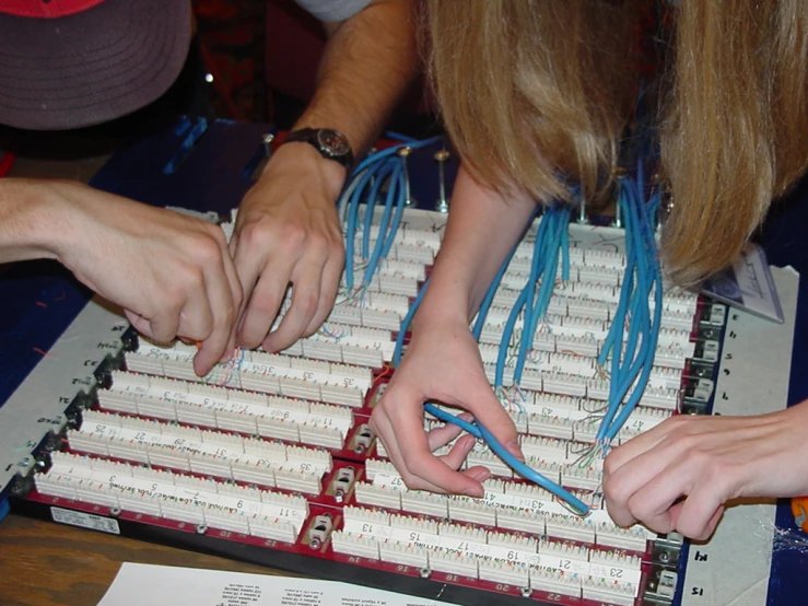 two people working on circuit boards with wires