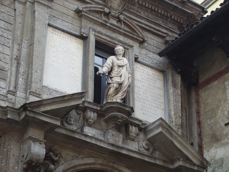 a statue sits on the balcony of a building