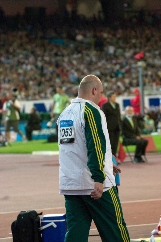 a man walking in a stadium during a race