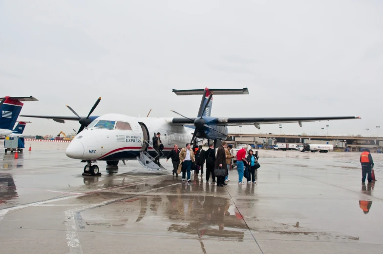 group of people getting off a plane at an airport