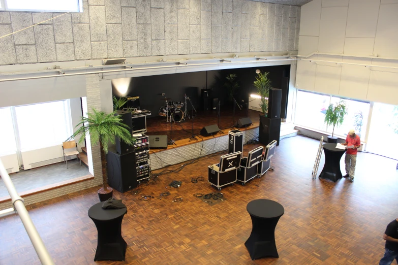 a large room with chairs, a stage and plants