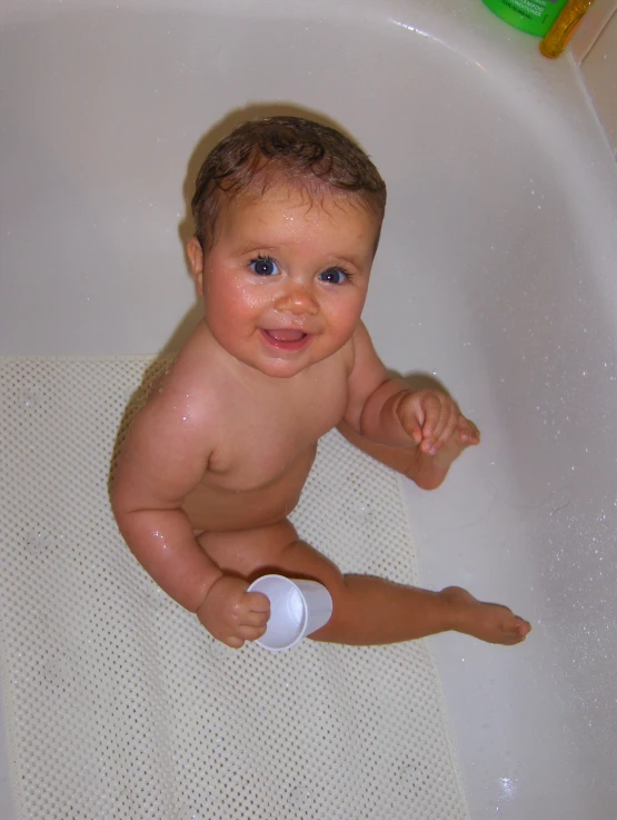 a close up of a baby sitting in a bathtub