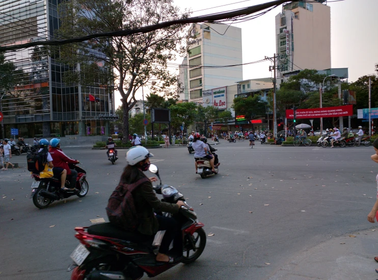 several people are on motor scooters in the middle of a street