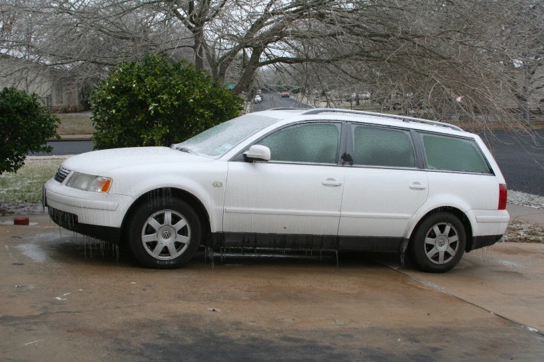 the white car is parked outside of the house