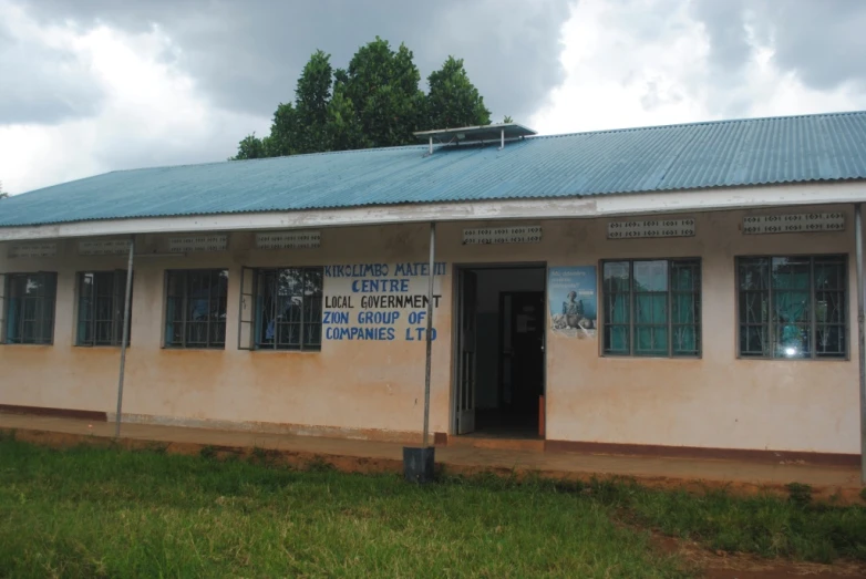 a school building with many windows in the grass