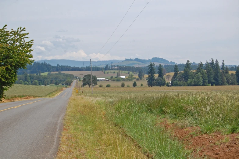 a rural road is pictured surrounded by the country side