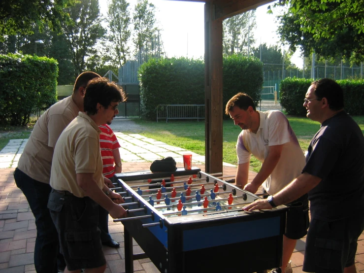 three men playing a game on the back deck